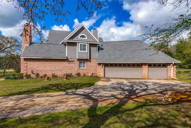 view of front of home featuring a front yard, an attached garage, a chimney, concrete driveway, and brick siding