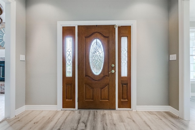 foyer entrance with light wood-type flooring and baseboards