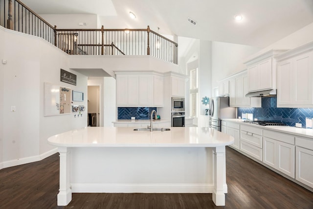 kitchen featuring light countertops, dark wood-style flooring, appliances with stainless steel finishes, and a sink