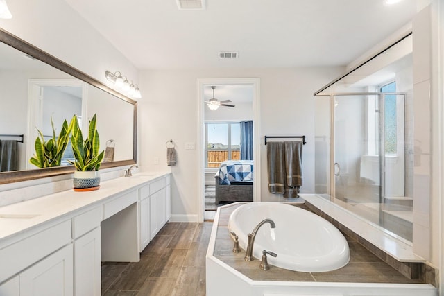 full bath with double vanity, connected bathroom, a healthy amount of sunlight, and a shower stall