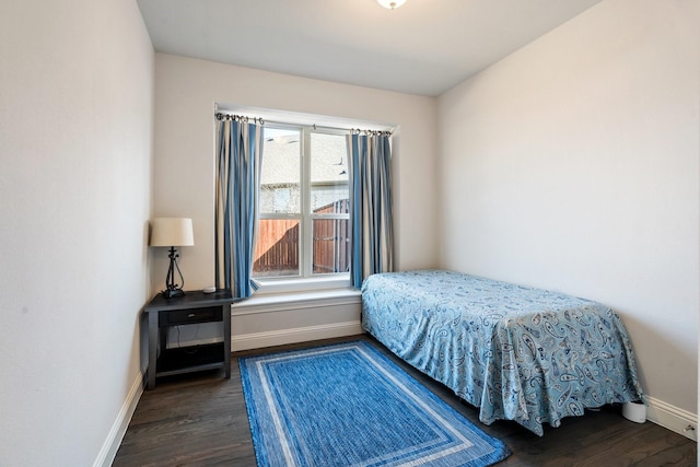 bedroom with baseboards and wood finished floors