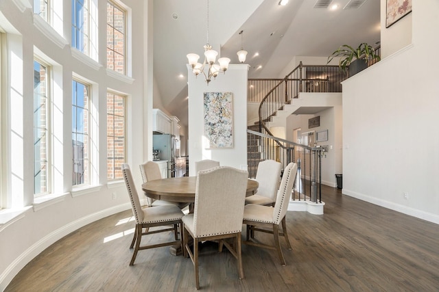 dining space featuring stairway, a chandelier, baseboards, a towering ceiling, and dark wood-style flooring