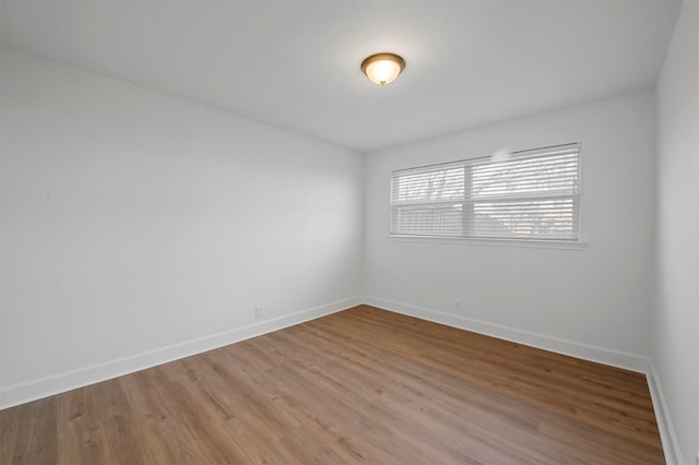 unfurnished room with baseboards and light wood finished floors