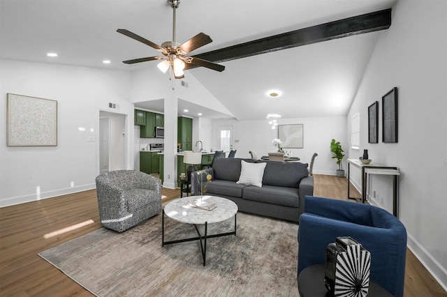 living room with lofted ceiling with beams, wood finished floors, baseboards, and ceiling fan