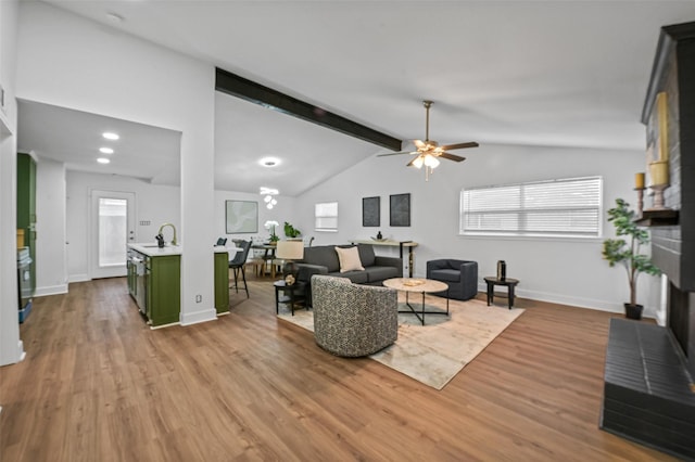 living room with lofted ceiling with beams, baseboards, wood finished floors, and a ceiling fan