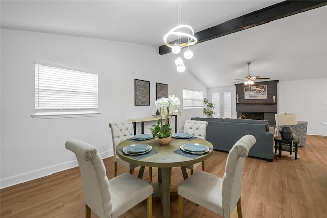 dining room featuring a ceiling fan, lofted ceiling with beams, baseboards, and light wood-type flooring