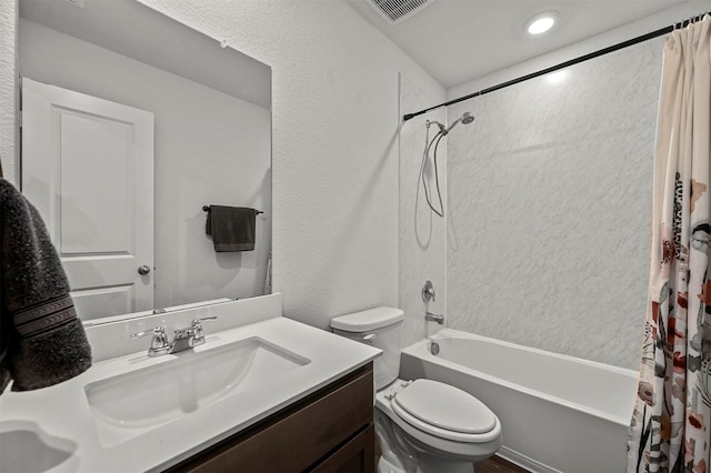 bathroom featuring visible vents, toilet, shower / tub combo, vanity, and a textured wall