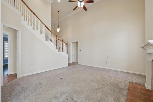 unfurnished living room with ceiling fan, stairs, and carpet