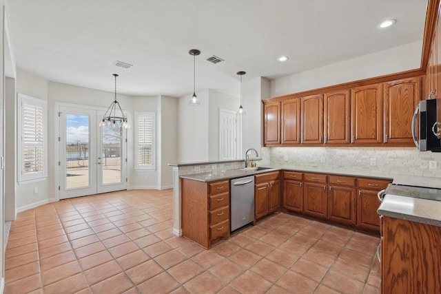 kitchen with a sink, visible vents, brown cabinets, and appliances with stainless steel finishes