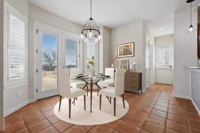 dining room featuring tile patterned floors, baseboards, and a notable chandelier