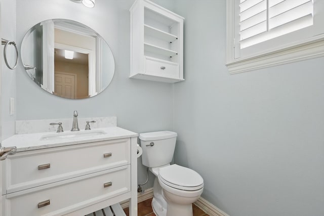 bathroom with vanity, toilet, and baseboards