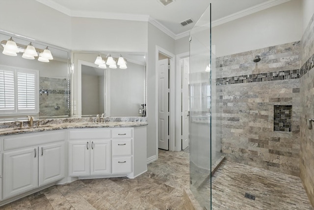 bathroom featuring vanity, crown molding, visible vents, and a tile shower