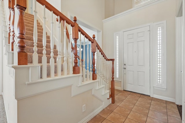 tiled foyer with stairway and baseboards