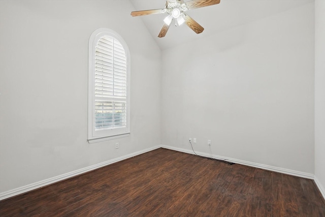 empty room with baseboards, lofted ceiling, dark wood finished floors, and a ceiling fan