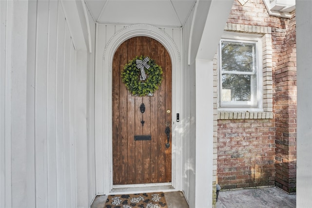 entrance to property featuring brick siding