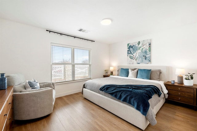 bedroom with visible vents, baseboards, and light wood-style floors