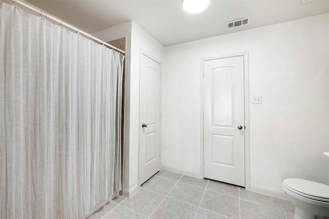 full bathroom featuring tile patterned floors, toilet, baseboards, and visible vents