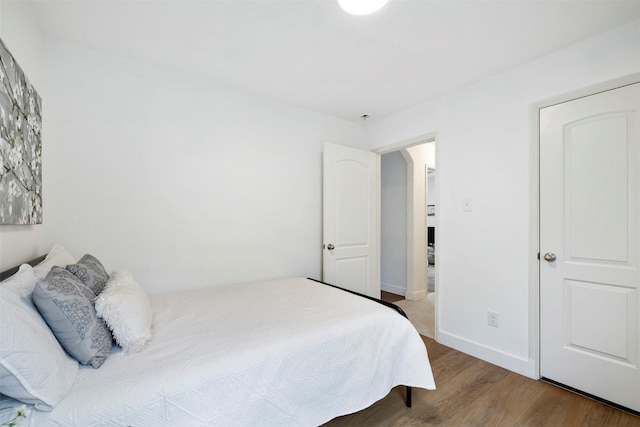 bedroom featuring wood finished floors and baseboards