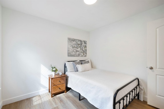 bedroom featuring baseboards and wood finished floors