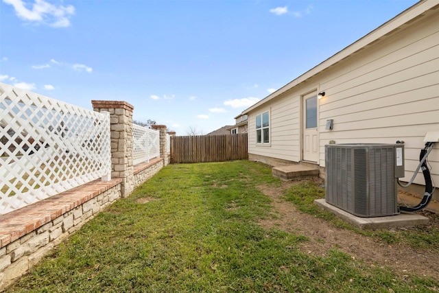 view of yard featuring a fenced backyard and central AC