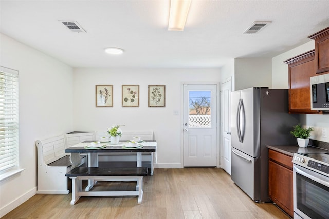 kitchen with light wood-style flooring, visible vents, and stainless steel appliances