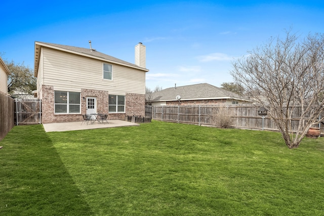 rear view of house with a fenced backyard, a chimney, a lawn, a patio area, and brick siding