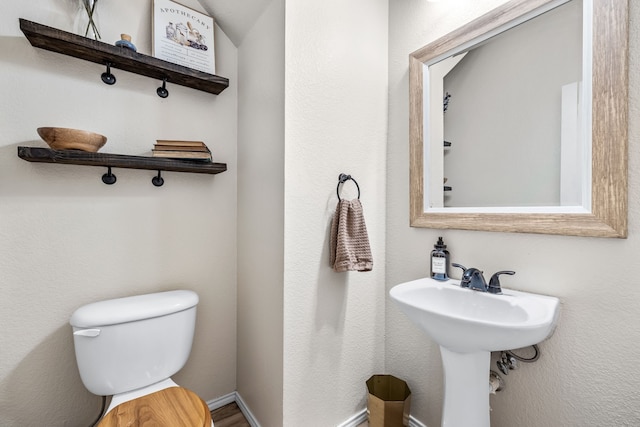 bathroom featuring toilet and baseboards