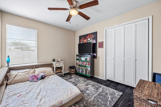 bedroom featuring a closet, baseboards, a ceiling fan, and dark wood-style flooring