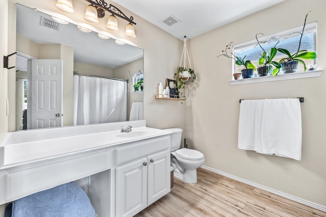 full bathroom with vanity, wood finished floors, visible vents, and baseboards