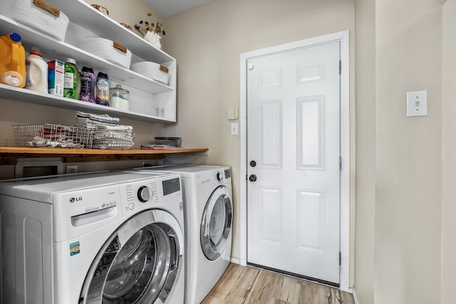 washroom with laundry area, light wood-type flooring, and separate washer and dryer