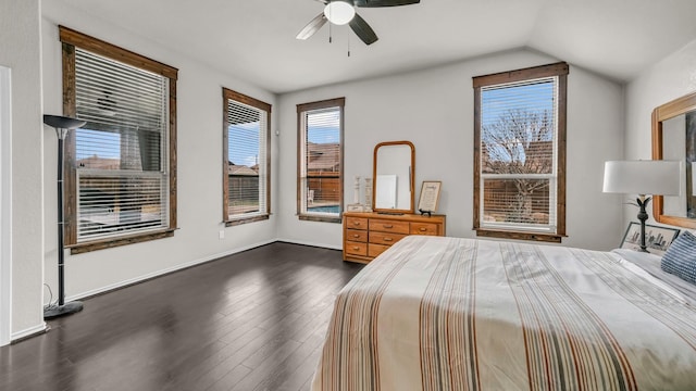 unfurnished bedroom featuring dark wood finished floors, lofted ceiling, baseboards, and ceiling fan