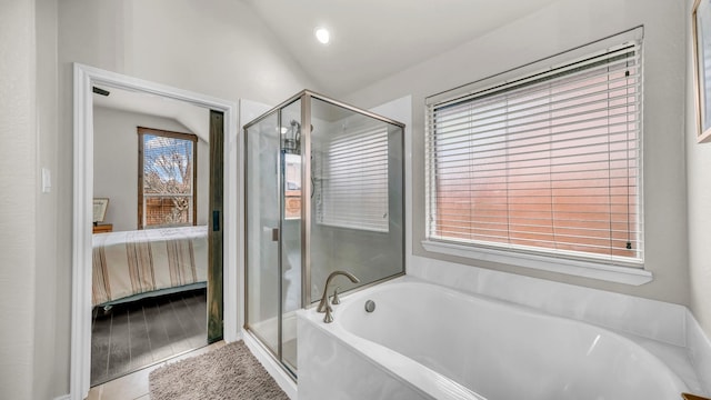 ensuite bathroom with ensuite bath, tile patterned flooring, vaulted ceiling, a shower stall, and a bath