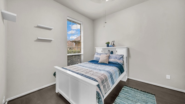 bedroom featuring baseboards and dark wood finished floors