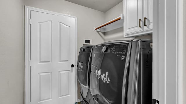 washroom with cabinet space and separate washer and dryer