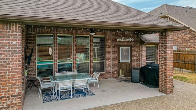 view of patio featuring outdoor dining area, a grill, ceiling fan, and fence