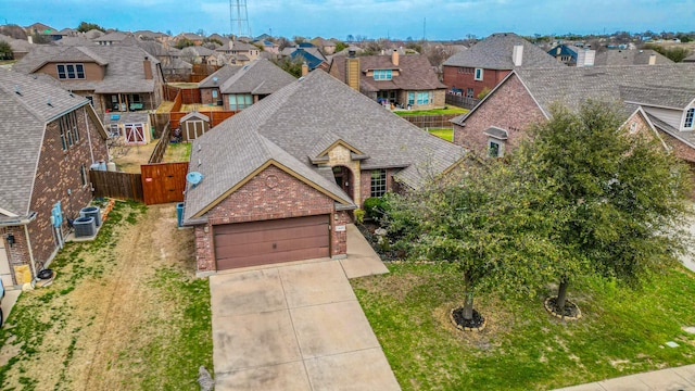 view of front facade with brick siding, a residential view, concrete driveway, roof with shingles, and a garage