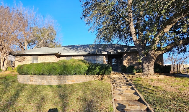 view of front of home with brick siding and a front yard