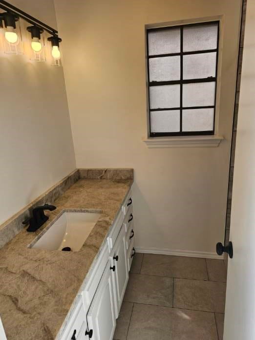 bathroom with tile patterned floors, baseboards, and vanity