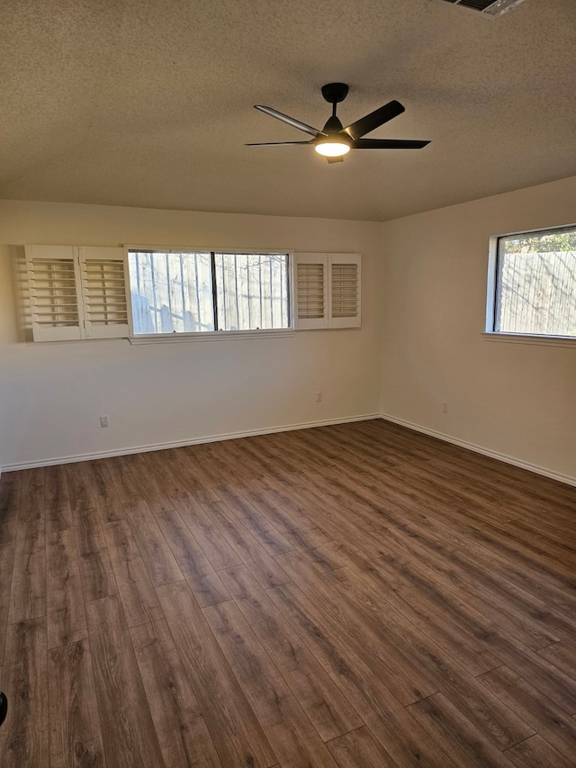 spare room featuring a textured ceiling, dark wood-type flooring, and a ceiling fan