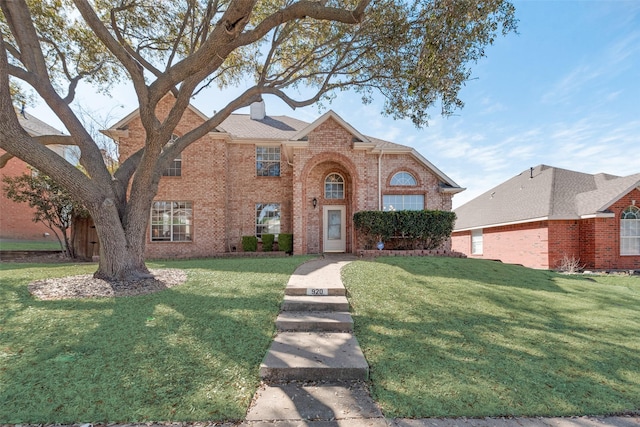 traditional-style house featuring a front yard, brick siding, and a chimney