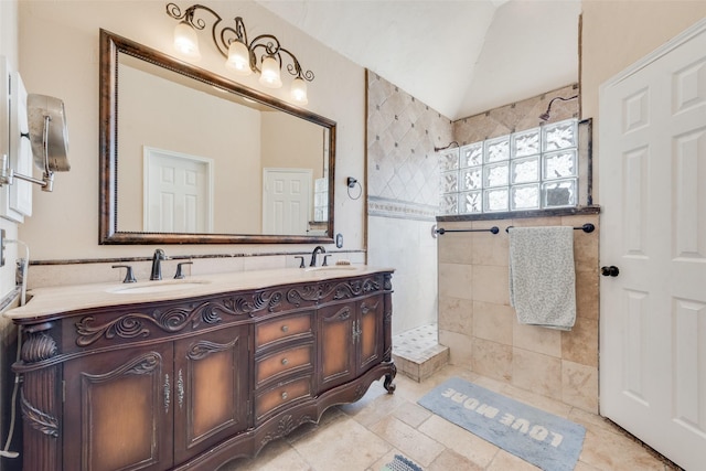 full bath featuring a sink, vaulted ceiling, double vanity, and a walk in shower