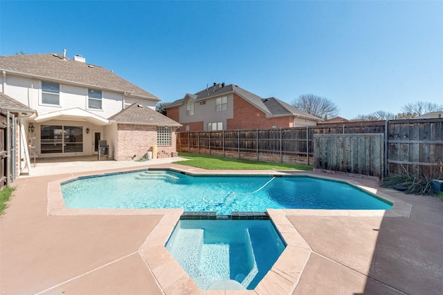 view of pool featuring a patio, a fenced backyard, and a pool with connected hot tub