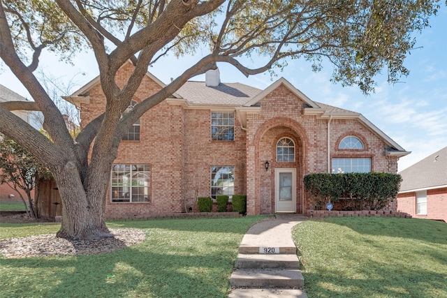 traditional home with a front lawn, brick siding, and a chimney