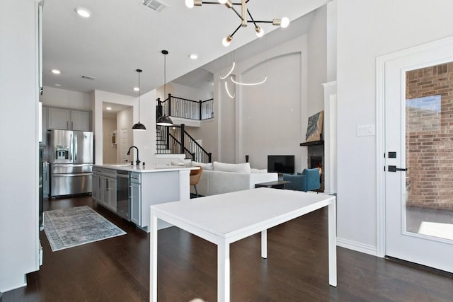 kitchen featuring a sink, appliances with stainless steel finishes, dark wood-style flooring, and gray cabinets