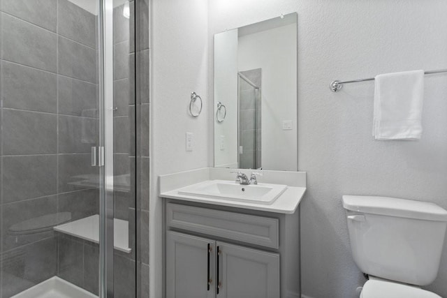 bathroom with vanity, toilet, and a shower stall