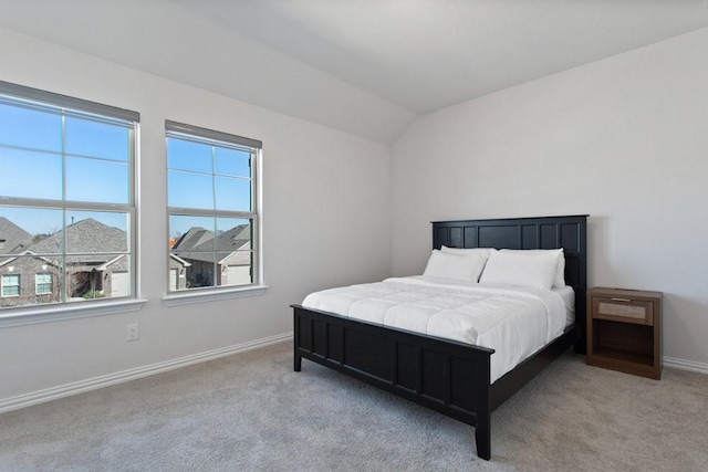 carpeted bedroom featuring baseboards and vaulted ceiling