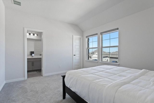 bedroom with visible vents, connected bathroom, baseboards, lofted ceiling, and carpet flooring