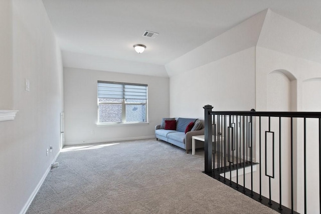 sitting room with visible vents, carpet floors, baseboards, and vaulted ceiling