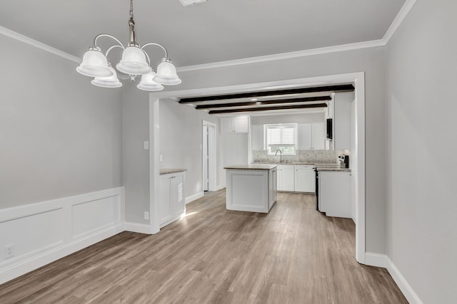 kitchen with light wood finished floors, electric range, a sink, white cabinetry, and a chandelier