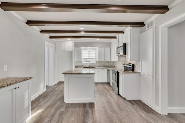 kitchen featuring tasteful backsplash, visible vents, beam ceiling, appliances with stainless steel finishes, and a sink